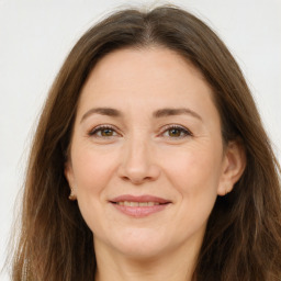 Joyful white adult female with long  brown hair and brown eyes