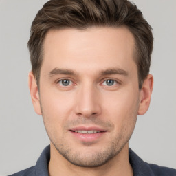 Joyful white young-adult male with short  brown hair and grey eyes