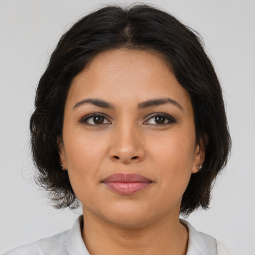 Joyful latino young-adult female with medium  brown hair and brown eyes