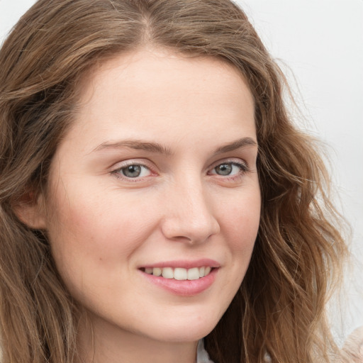 Joyful white young-adult female with long  brown hair and blue eyes