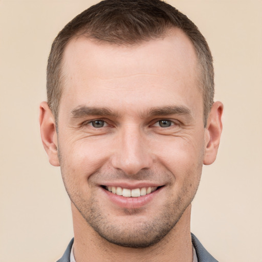 Joyful white young-adult male with short  brown hair and grey eyes