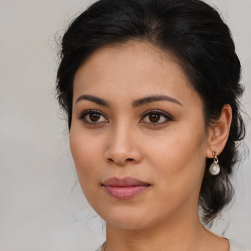 Joyful latino young-adult female with medium  brown hair and brown eyes