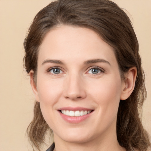 Joyful white young-adult female with medium  brown hair and grey eyes