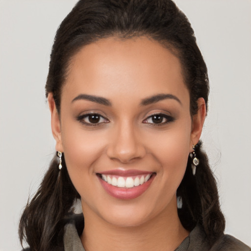 Joyful latino young-adult female with long  brown hair and brown eyes