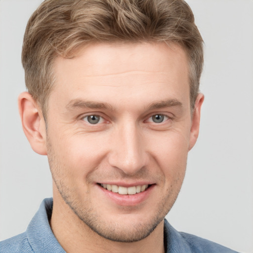 Joyful white young-adult male with short  brown hair and grey eyes