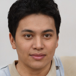 Joyful latino young-adult male with short  brown hair and brown eyes