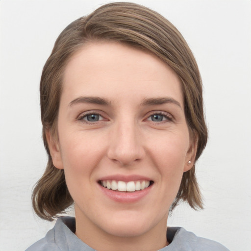 Joyful white young-adult female with medium  brown hair and grey eyes