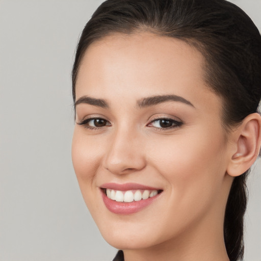 Joyful white young-adult female with long  brown hair and brown eyes