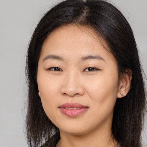Joyful asian young-adult female with long  brown hair and brown eyes