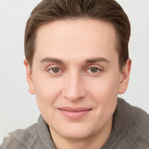 Joyful white young-adult male with short  brown hair and grey eyes