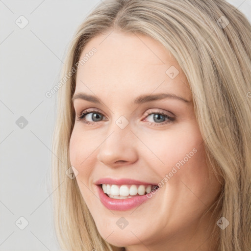 Joyful white young-adult female with long  brown hair and blue eyes