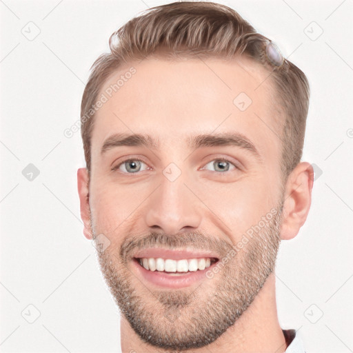 Joyful white young-adult male with short  brown hair and grey eyes