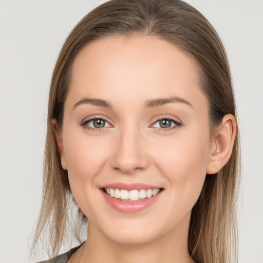 Joyful white young-adult female with long  brown hair and grey eyes