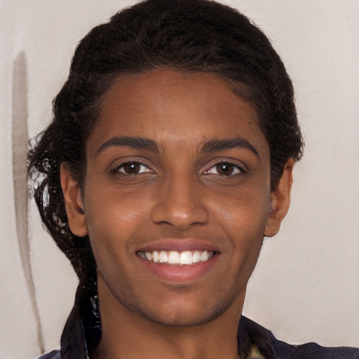 Joyful black young-adult female with long  brown hair and brown eyes