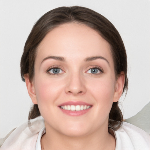 Joyful white young-adult female with medium  brown hair and blue eyes