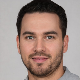 Joyful white young-adult male with short  black hair and brown eyes