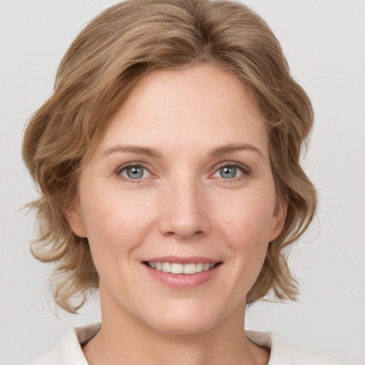 Joyful white young-adult female with medium  brown hair and blue eyes