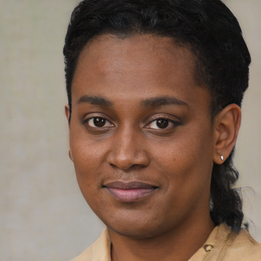Joyful black young-adult female with short  black hair and brown eyes