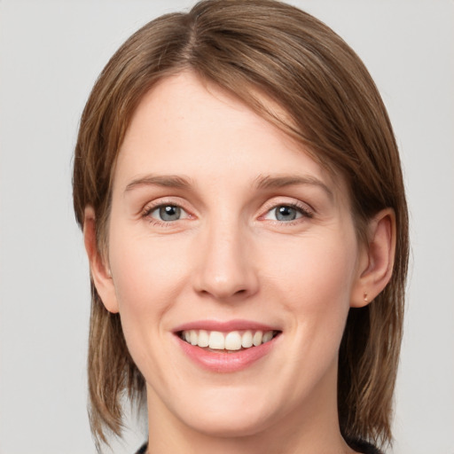 Joyful white young-adult female with medium  brown hair and grey eyes