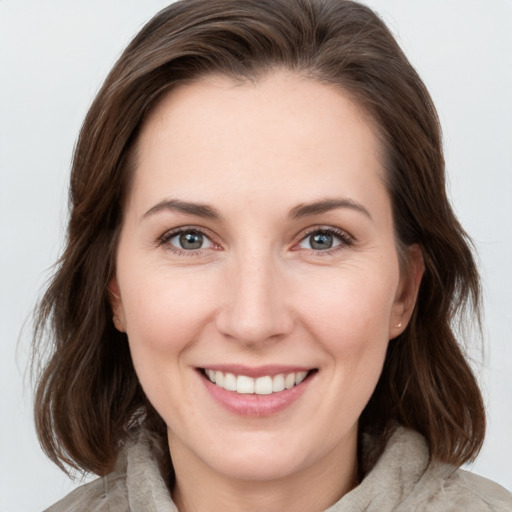 Joyful white young-adult female with medium  brown hair and blue eyes