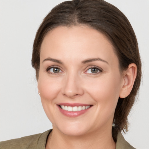 Joyful white young-adult female with medium  brown hair and grey eyes