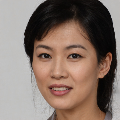 Joyful asian young-adult female with medium  black hair and brown eyes