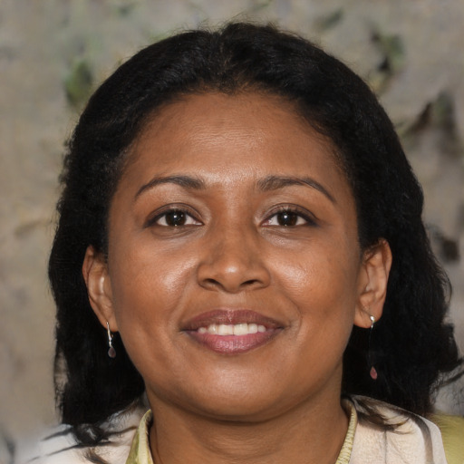 Joyful latino adult female with medium  brown hair and brown eyes