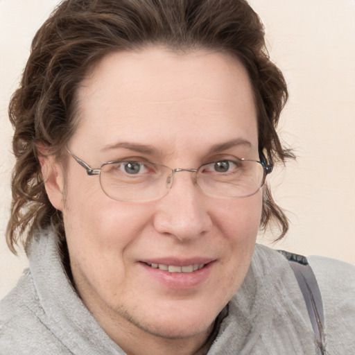 Joyful white adult female with medium  brown hair and blue eyes