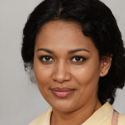 Joyful black adult female with medium  brown hair and brown eyes