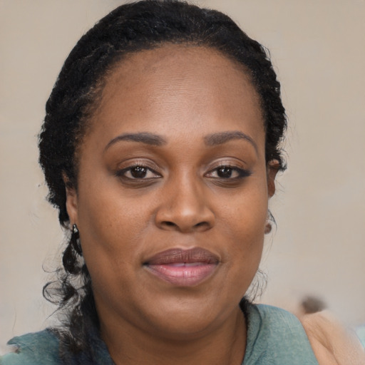 Joyful black young-adult female with long  brown hair and brown eyes