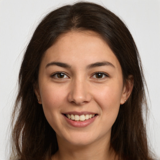 Joyful white young-adult female with long  brown hair and brown eyes