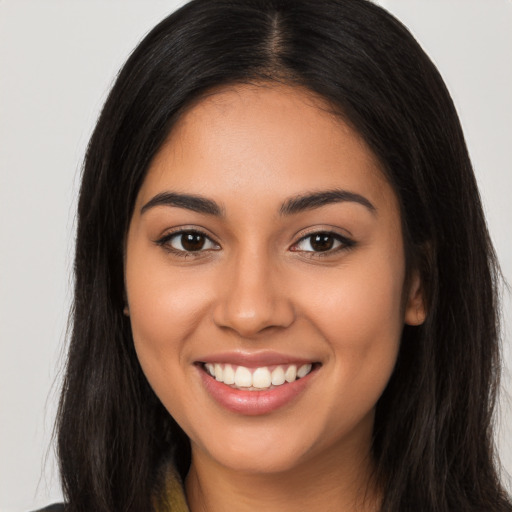 Joyful latino young-adult female with long  brown hair and brown eyes