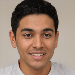 Joyful latino young-adult male with short  brown hair and brown eyes