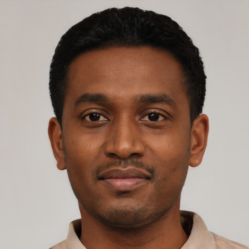 Joyful black young-adult male with short  black hair and brown eyes