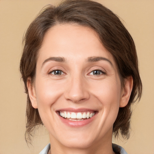 Joyful white adult female with medium  brown hair and grey eyes