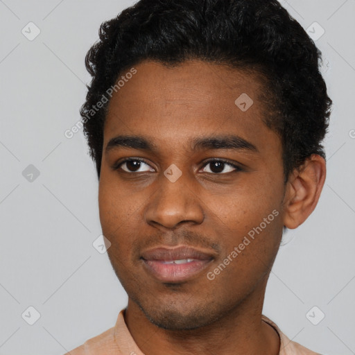 Joyful black young-adult male with short  black hair and brown eyes