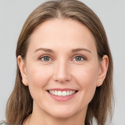 Joyful white young-adult female with medium  brown hair and grey eyes