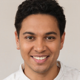 Joyful latino young-adult male with short  brown hair and brown eyes