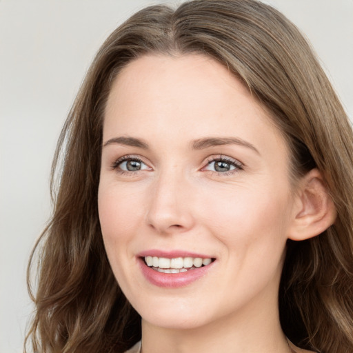 Joyful white young-adult female with long  brown hair and blue eyes