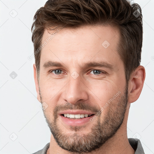 Joyful white young-adult male with short  brown hair and grey eyes