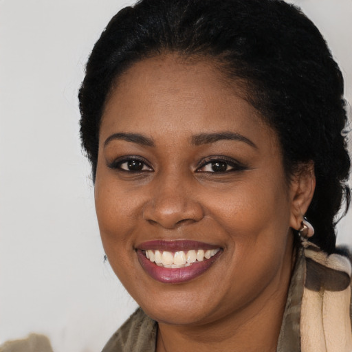 Joyful black young-adult female with long  black hair and brown eyes