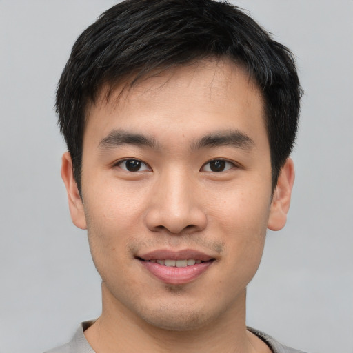 Joyful asian young-adult male with short  black hair and brown eyes