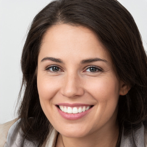 Joyful white young-adult female with long  brown hair and brown eyes