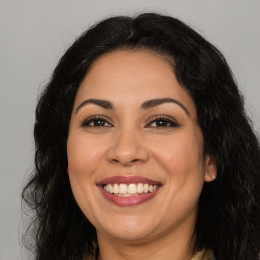 Joyful latino adult female with long  brown hair and brown eyes