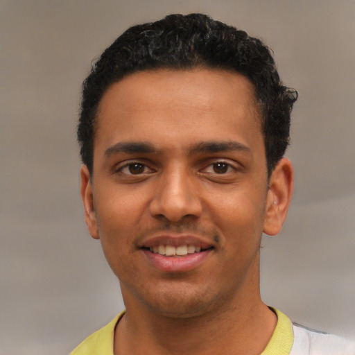 Joyful latino young-adult male with short  black hair and brown eyes