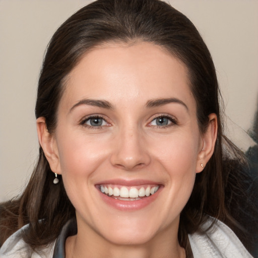 Joyful white young-adult female with medium  brown hair and grey eyes