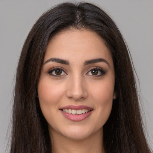 Joyful white young-adult female with long  brown hair and brown eyes