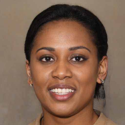 Joyful black young-adult female with long  black hair and brown eyes
