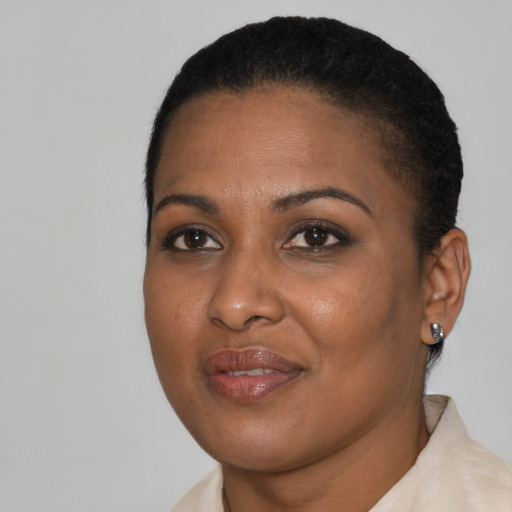 Joyful black young-adult female with short  black hair and brown eyes