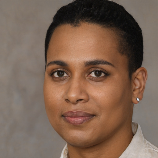 Joyful black young-adult female with short  black hair and brown eyes